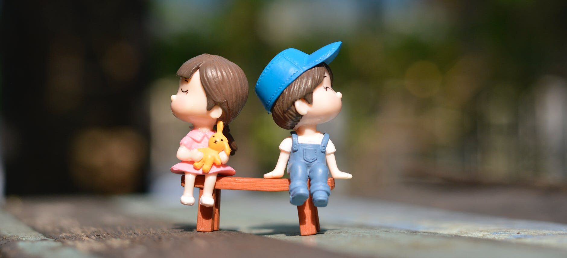 boy and girl sitting on bench toy